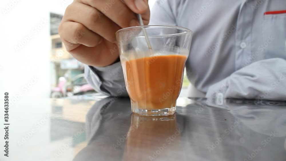 businessman stirring hot milk tea businessman stirring hot milk tea
