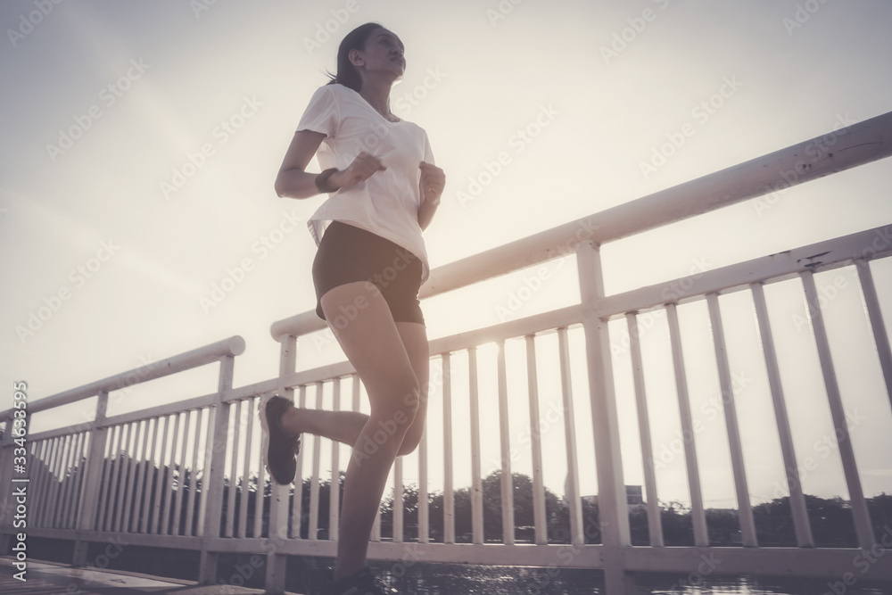 Obraz premium Healthy woman doing exercises and warm up before running and jogging on bridge at morning