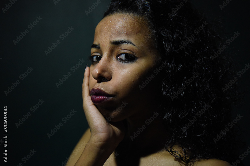 young naked African woman posing at studio, face with hand portrait over dark background young naked African woman posing at studio, face with hand portrait over dark background