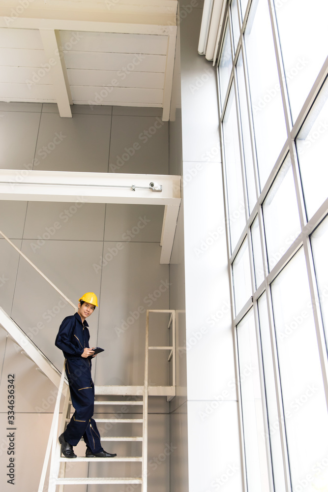 Young engineer standing on metal staircase.