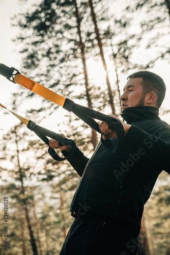 asian guy training in forest in the sunset