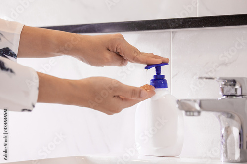 Fototapeta Naklejka Na Ścianę i Meble -  Women washing hands with antibacterial soap sanitizer or alcohol gel for corona covid-19 virus prevention. Hygiene to stop spreading of germs and bacteria and avoid infections corona covid-19 virus.