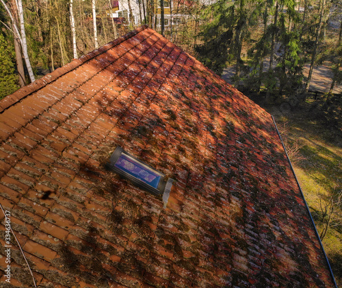 Inspection of the red tiles of the roof of a family house with a drone  aerial photo