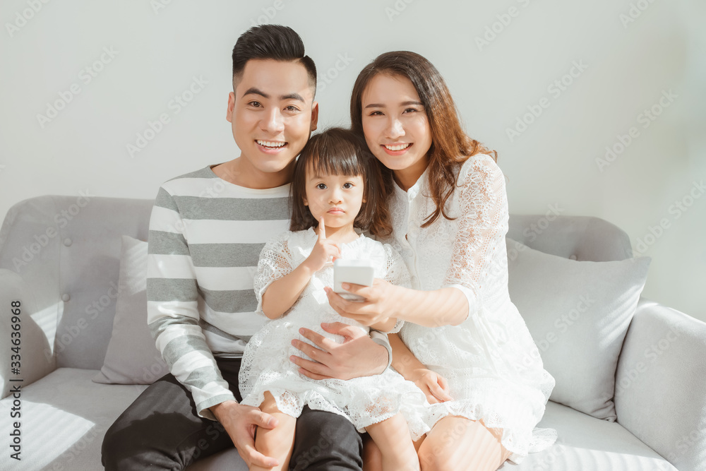 Happy family with children using mobile apps together at home Happy family with children using mobile apps together at home