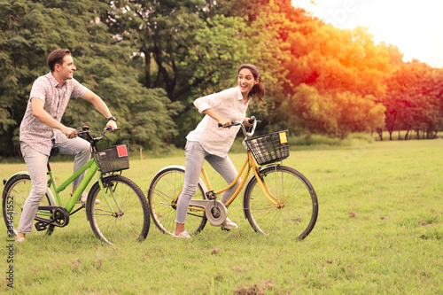 Couple love resting or relaxing in a green park, hugging action and looking forward and ride on back for romantic date or vacation in valentine day