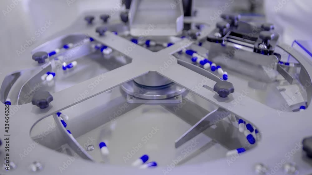 Blue pills for COVID-19 treatment spinning on a plate during counting process on the production line Blue pills for COVID-19 treatment spinning on a plate during counting process on the production line