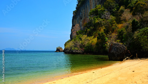 Mountain cliff view with sand beach on tropical island in South of Thailand.