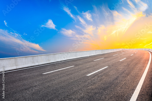 Asphalt highway road and sky sunset clouds landscape.