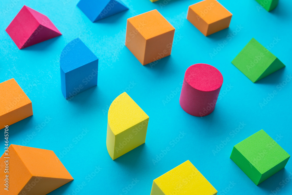 Obraz premium Set of colorful geometric cube or block toy on blue background. Abstract pattern design composition by shape and form. Education and creative design product concept.