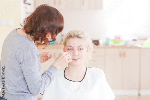 Make up artist apply foundation to model face