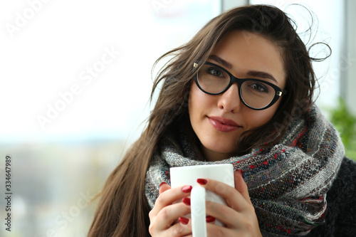 Beautiful smiling girl in a scarf portrait hold in arms big cup portrait. photo