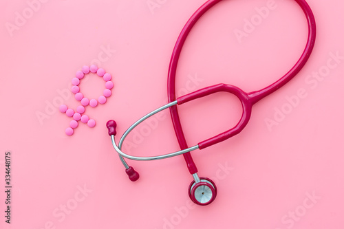 Women's Health issues. Medical concept with Venus sign and stethoscope on pink background top-down