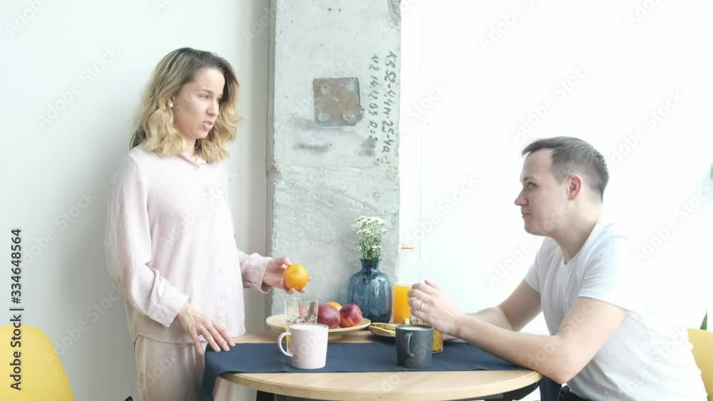pretty young couple in love having tasty breakfast while sitting at the table in a kitchen pretty young couple in love having tasty breakfast while sitting at the table in a kitchen