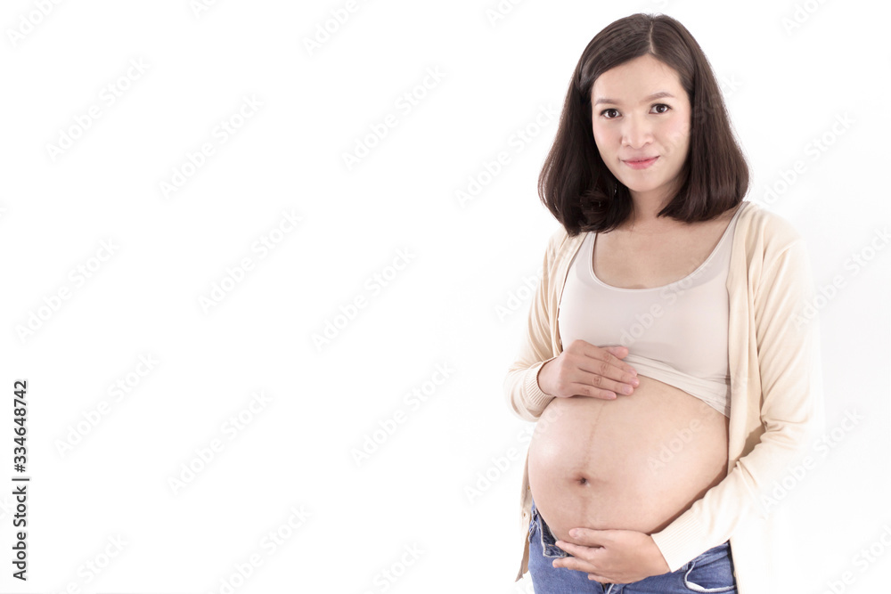 Happy pregnant asian woman sitting on bed and touching her big belly Happy pregnant asian woman sitting on bed and touching her big belly