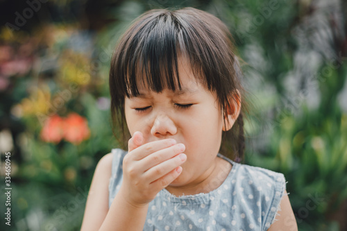 Wall Mural Kids using hand covering her mouth while cough which is incorrect sneezing posture