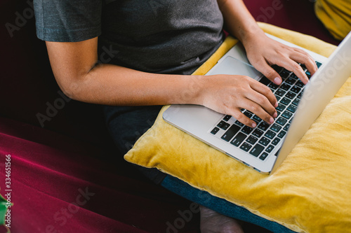 Young woman working on laptop computer while sitting on the sofa at living home.work at home concept,