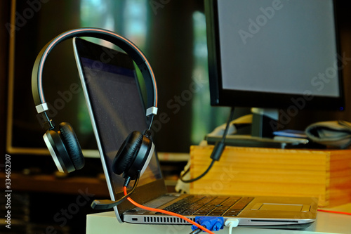 Head set on laptop and external Monitor for work from home concept.