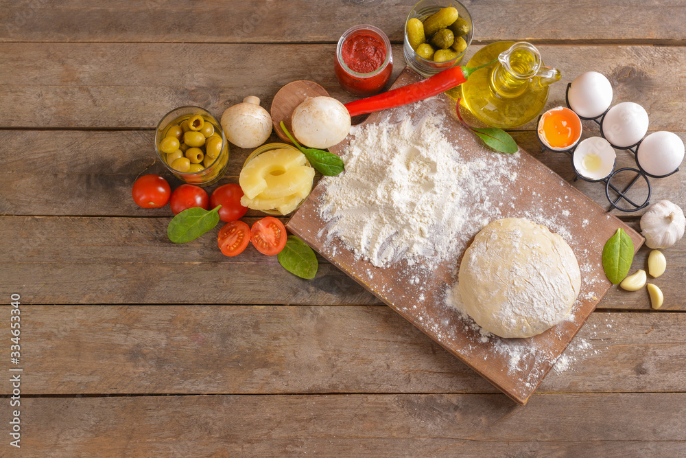 Ingredients for tasty pizza on wooden background Ingredients for tasty pizza on wooden background