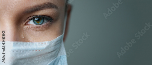 Fotografia A female doctor therapist in a white robe, mask and gloves