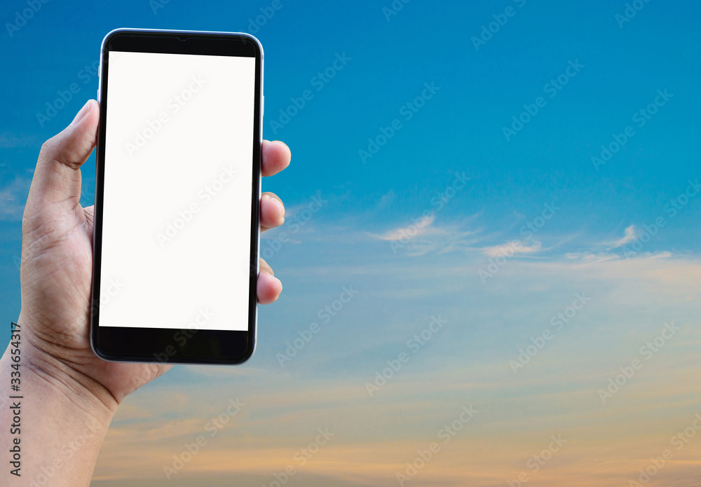 Mobile phone in hand on sky background