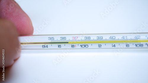 Thermometer with hand on white background