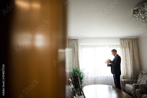 Beautiful man, groom posing and preparing for wedding