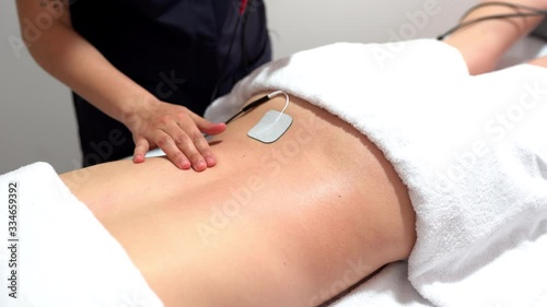 Electro stimulation in physical therapy to a young woman