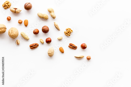 Nuts background - with almond, macadamia, walnut, hazelnut, pecans - on white table top-down copy space