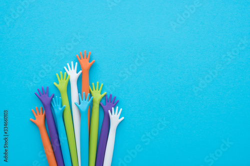 Many colorful hands up on blue background with copy space. Concept of international human rights, equality and peace. Color hands are symbol of diversity. photo