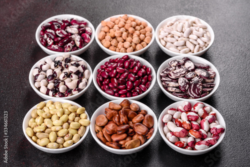 Pulses health food selection in white porcelain dishes over concrete background