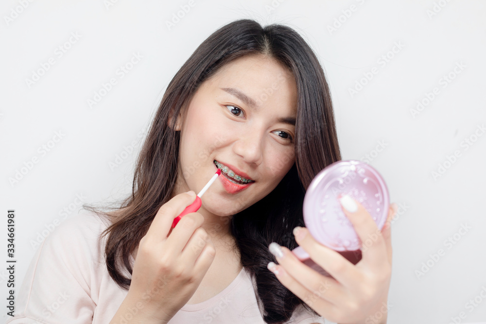 A beautiful Asian model is using lipstick. A beautiful Asian model is using lipstick.