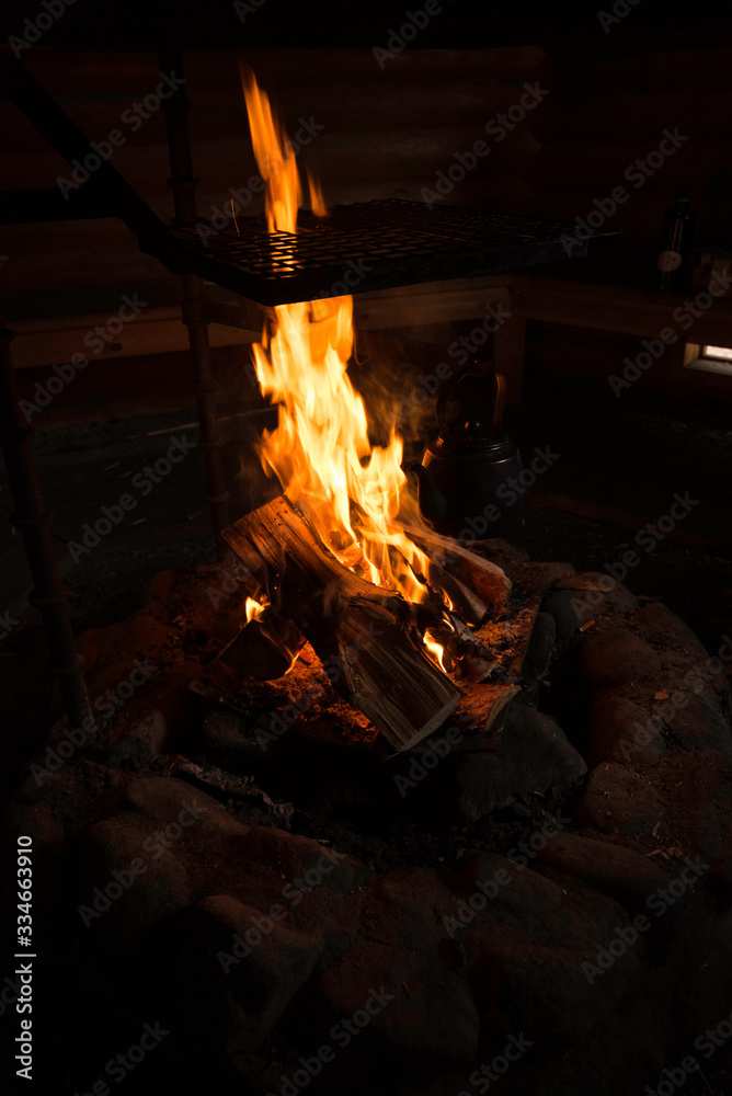 Cooking fire inside hut with kettle