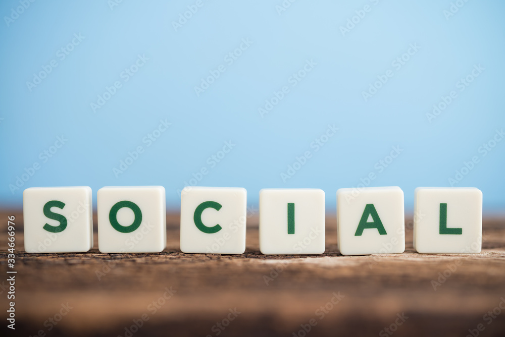 Word SOCIAL on wooden desk with blue background copy space. Social media, network connection, business and marketing concept. Word SOCIAL on wooden desk with blue background copy space. Social media, network connection, business and marketing concept.