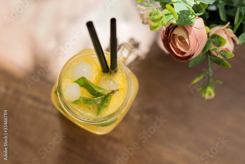 Glass of yellow alcohol-free cocktail with lemons and mint