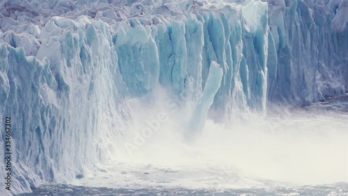 Ice of glacier collapsing to the lake. Slow motion photo