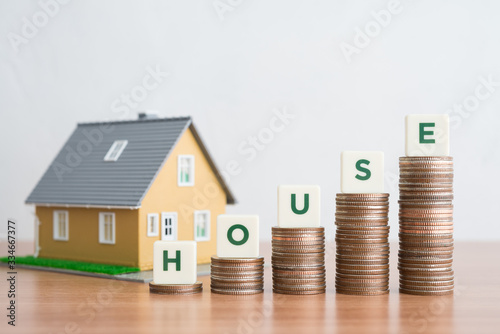 Green word HOUSE on step stack coins as graph with house model. Money saving for new house, home loan, reverse mortgage and real estate property business concept