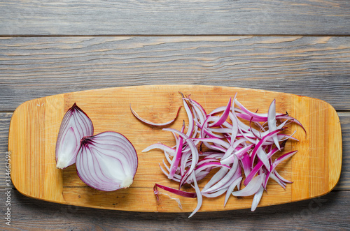 Red onion sliced. The process of cooking on a yellow cutting Board. Flat top view