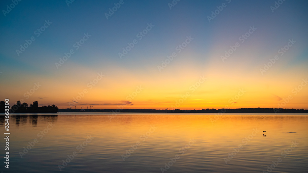 Golden sunbeams reflecting on the sea at sunrise