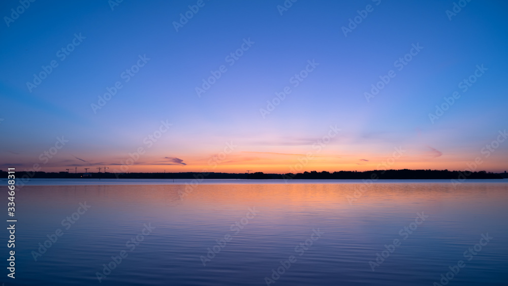 Sky at dawn and peaceful lake; beautiful view of sunrise