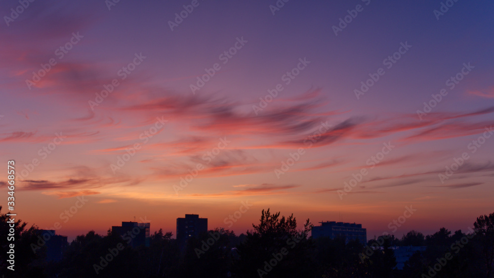 Silhouette of orange sky at sunset and buildings in the city; colorful senset