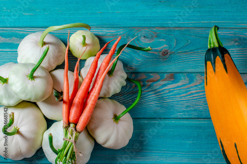 Vegetable set: carrots, patisons with green tails and multi-colored zucchini lie on an old wooden table photo