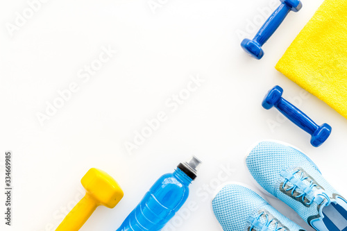 Athletics accessories. Dumbbells, towel, sneakers on white background top-down copy space