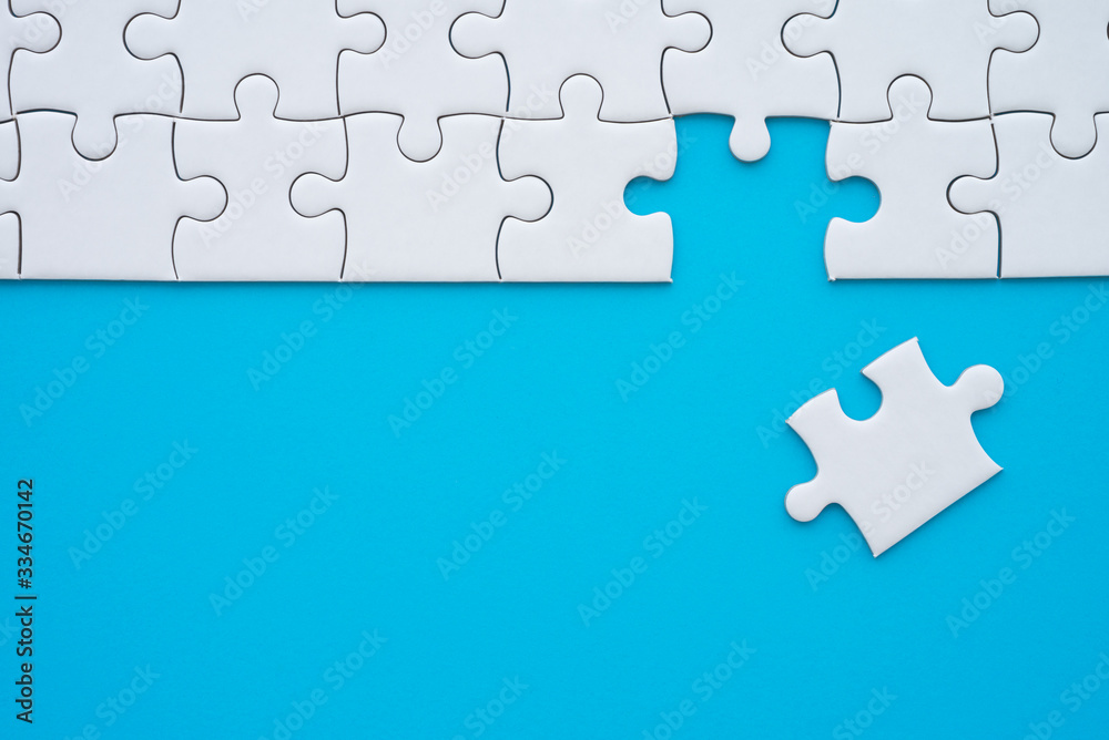 The last piece of jigsaw puzzle to complete task on blue background. Business strategy teamwork, problem solving concept. Teamwork is collaborative effort of team to achieve goal or complete mission. The last piece of jigsaw puzzle to complete task on blue background. Business strategy teamwork, problem solving concept. Teamwork is collaborative effort of team to achieve goal or complete mission.
