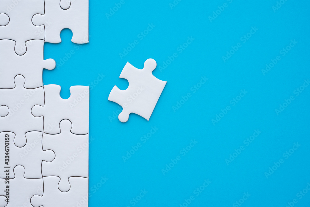 The last piece of jigsaw puzzle to complete task on blue background. Business strategy teamwork, problem solving concept. Teamwork is collaborative effort of team to achieve goal or complete mission. The last piece of jigsaw puzzle to complete task on blue background. Business strategy teamwork, problem solving concept. Teamwork is collaborative effort of team to achieve goal or complete mission.