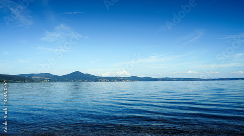 Panorama of Lake Bracciano in Roma of Italy. Beautiful lakescape and mountains under blue sky