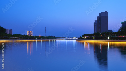 Night view of city buildings and river with blue background