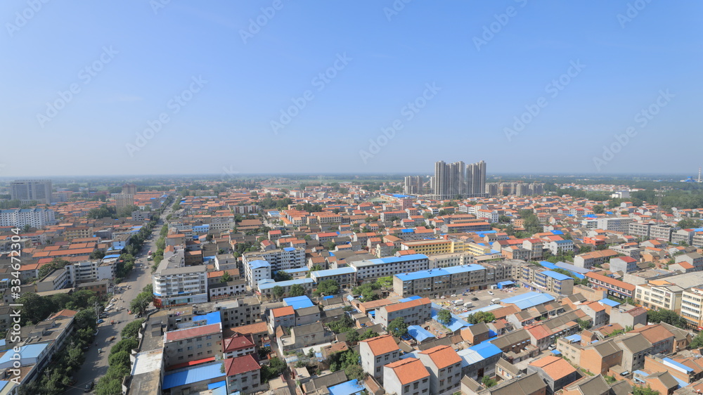 Aerial panoramic view of cityscape, town under blue sky