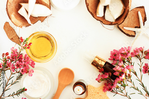 Natural cosmetics skincare spa, coconut oil, facial treatment bottle, herbal esential oils.  Framed top view body care beauty background.