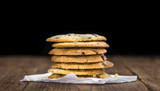 Old wooden table with fresh Chocolate Chip Cookies (close-up shot; selective focus)
