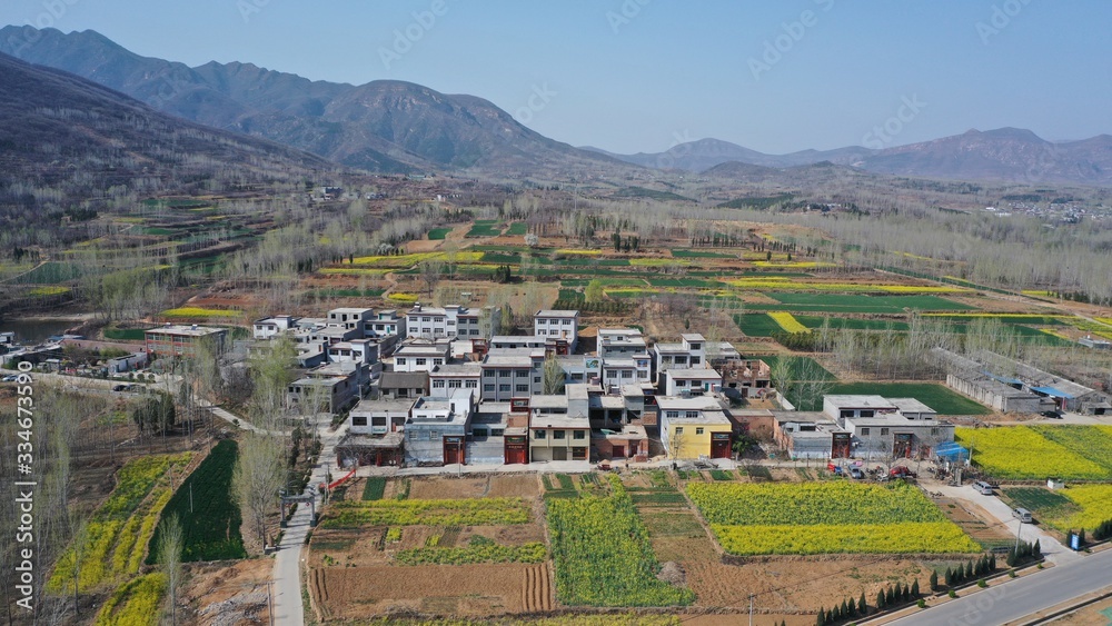 Aerial view of Chinese countryside, houses in farmland, hills 